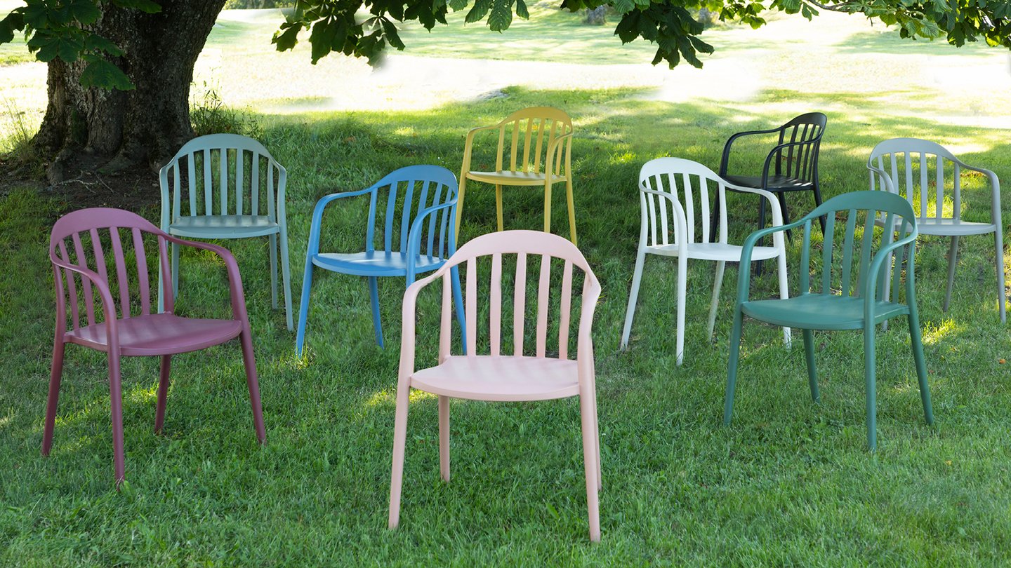 Vika stoler i ulike farger på en gressplen. 