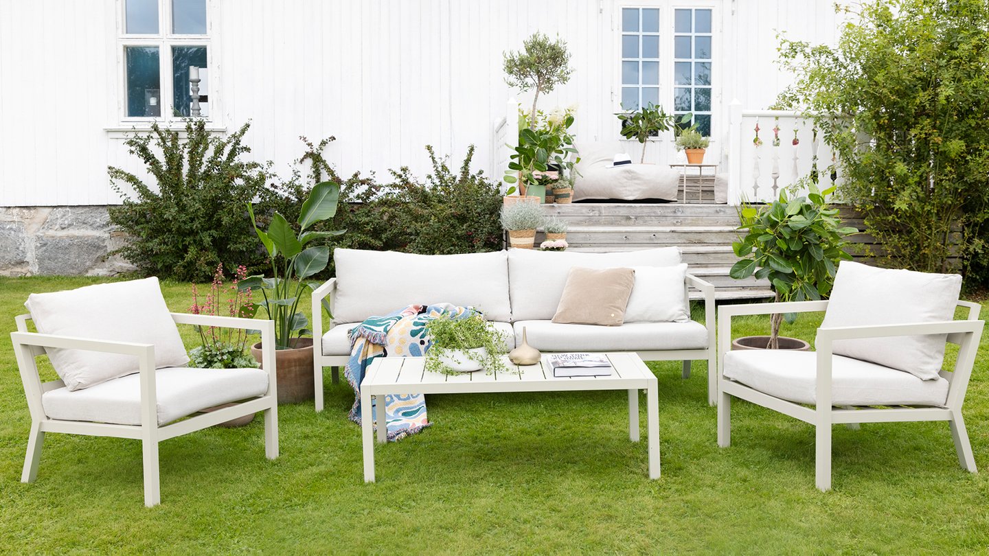 Røst sofaserie i hvit på en gressplen.