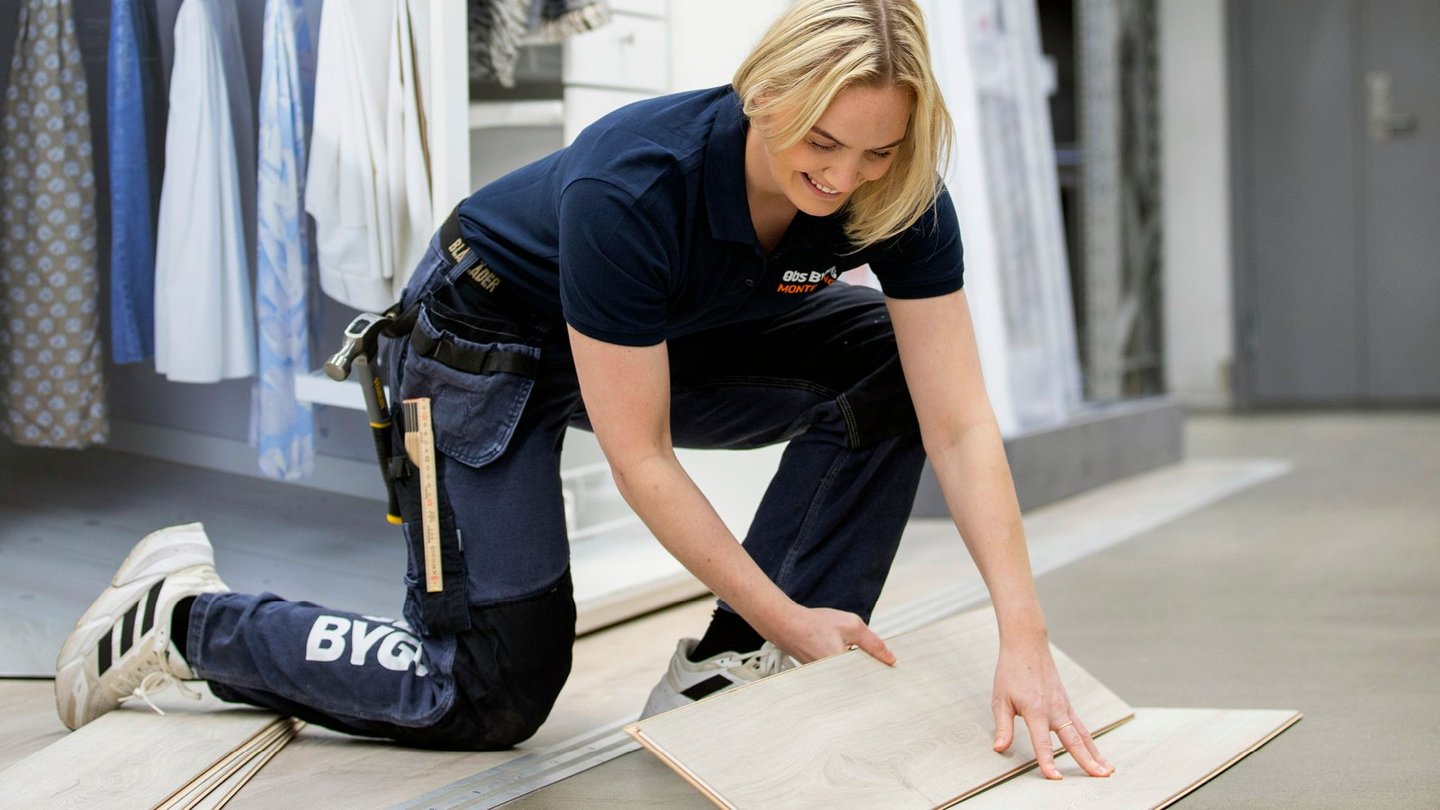 Kvinne hos OBM som legger gulv