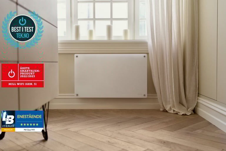 Hvit panelovn montert under et vindu med gardiner i en lys stue.