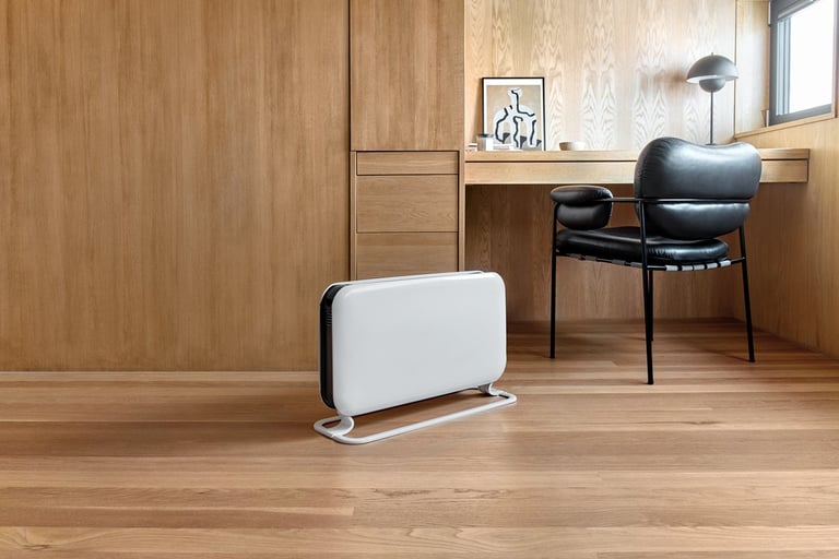 Hvit gulvovn på kontor med trepaneler.