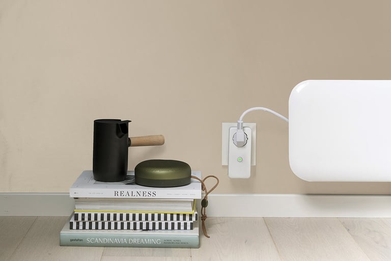 Hvit Mill WiFi Socket koblet til stikkontakt til en panelovn.