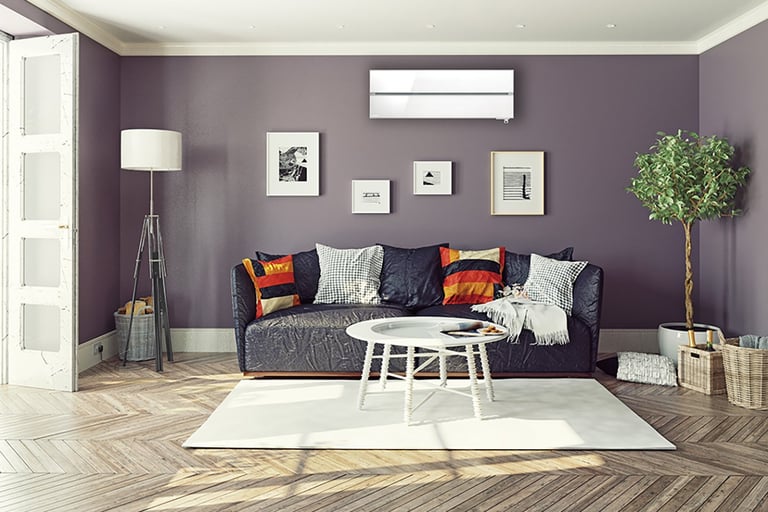 Moderne stue med vegghengt luft/luft-varmepumpe plassert over sofaen.