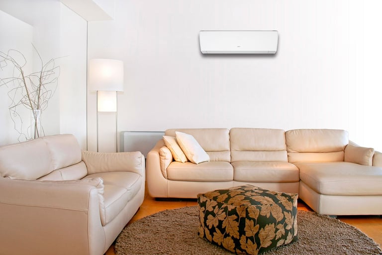 Stue med sofa og varmepumpe montert på hvit vegg.
