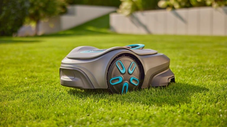 Trådløs Gardena Sileno robotklipper på en grønn plen foran et hus.