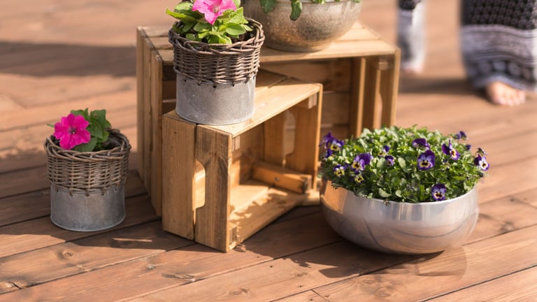 Blomster i potter som står på royalimpregnert terrassebord