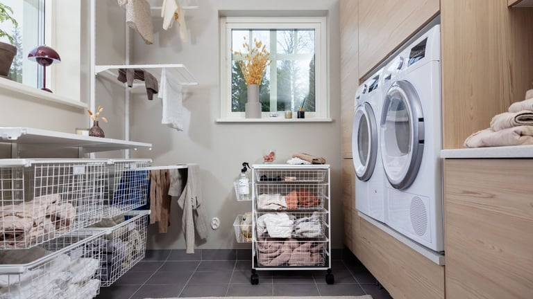 Vaskerom med hyller, kurver, skapplass og tørketrommel.