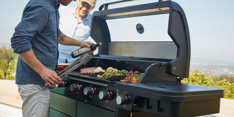 Mann griller mat ute, på en solværsdag på en gassgrill fra FCC.
