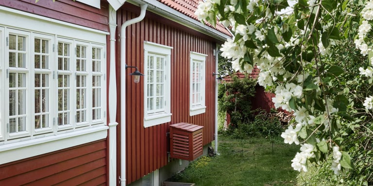 Rødt hus med hvite karmer rundt vinduene