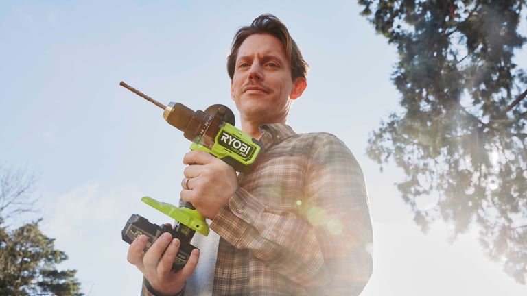 Person holder Ryobi drill med EDGE-batteri utendørs.