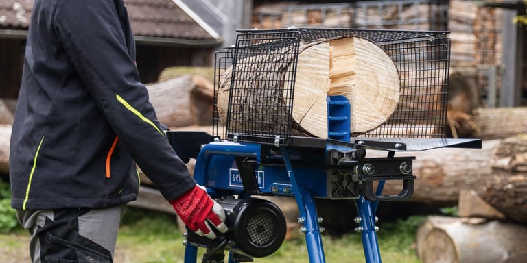 Person bruker Scheppach HL570LS elektrisk vedkløyver til stor vedkubbe utendørs.